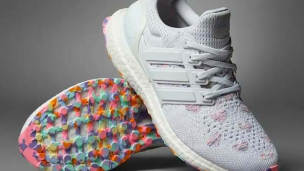 View of white and pink Adidas shoes.
